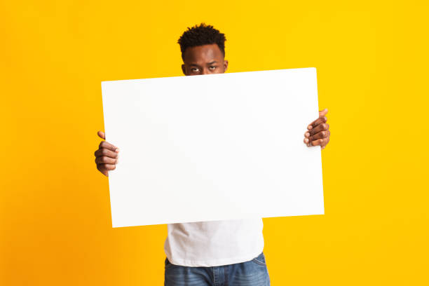 istock African man showing blank white big A2 paper 1209015753
