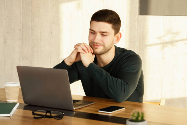 istock Smiling Man At Laptop Looking At Computer Working In Office 1209015827