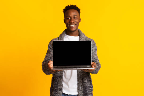 istock Young excited joyful african man holding in hands laptop 1209015923