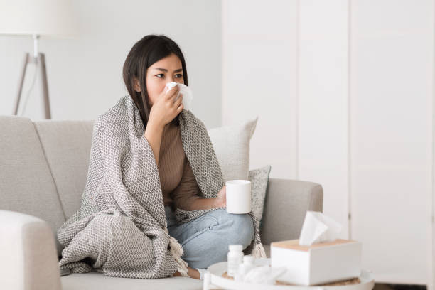 istock Cold and flu. Sick girl with runny nose drinking hot tea 1209016372