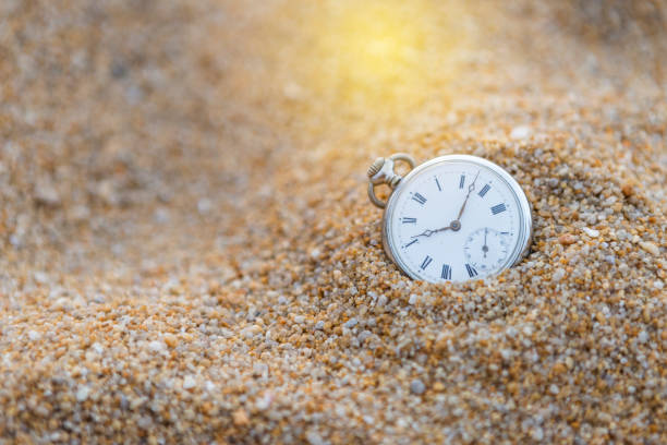istock Vintage watch on sand with vintage warm light 1209016527