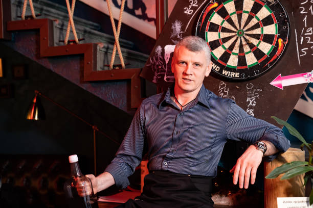 istock man is sitting in bar with large bottle of alcohol 1209016577