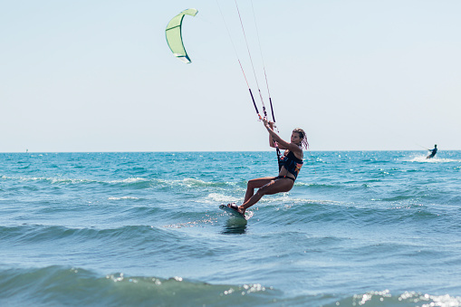 Attractive young woman  kite boarding while on a vacation