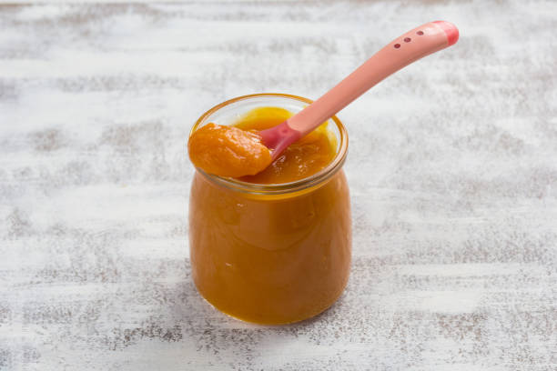 istock Pumpkin puree in glass jar and spoon on the white background 1209018819