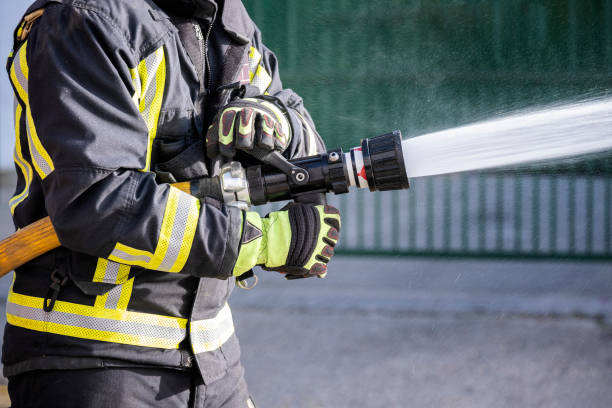 消火器とホース水を使用して火災と戦う消防士 - extinguishing ストックフォトと画像