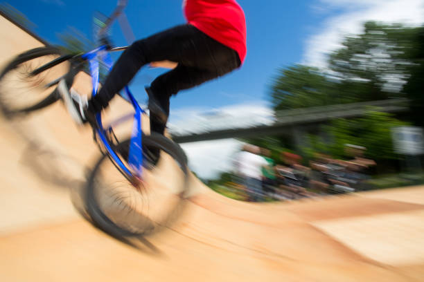 bmx всадника перепрыгивая на u рампы в скейтпарк - bmx cycling bicycle cycling backflipping стоковые фото и изображения