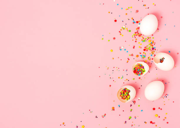 istock Creative easter background. Colorful confetti in eggshell on the pink background. Copy space, top view 1209022611