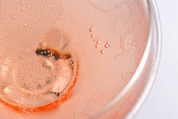 verre rose de champagne de rose avec des bulles - pink champagne photos et images de collection
