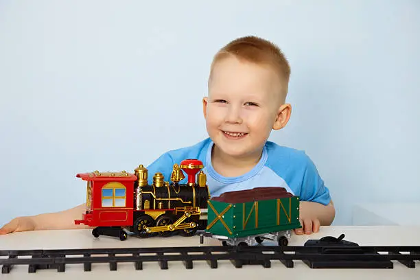 Little boy playing with a toy railway