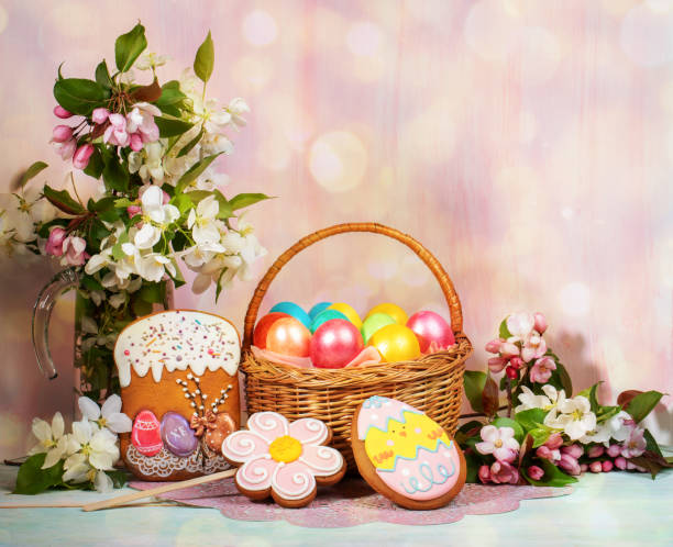 istock Easter composition of basket of painted Easter eggs, painted gingerbreads, Apple tree twigs with backdrop with bokeh. 1209028944