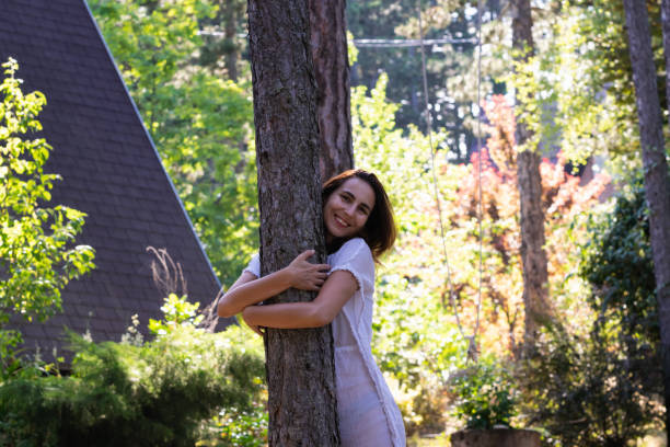 istock Beautiful woman embracing pine tree. 1209029238