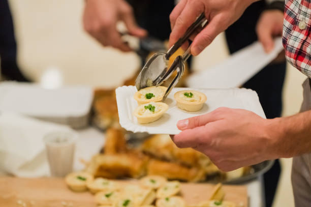 istock Man serving himself with vegetarian canapes at celebration event. 1209032110