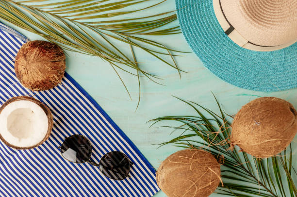 istock Summer composition or layout. Tropical palm leaves, hat, glasses, beach towel, coconut on a background of sea greens. The concept of the summer season and heat. Flat lay, top view, copy space 1209032943