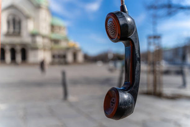 handphone hanging in telephone booth in front of alexander nevski cathedral in sofia, bulgaria - coin operated pay phone telephone communication imagens e fotografias de stock