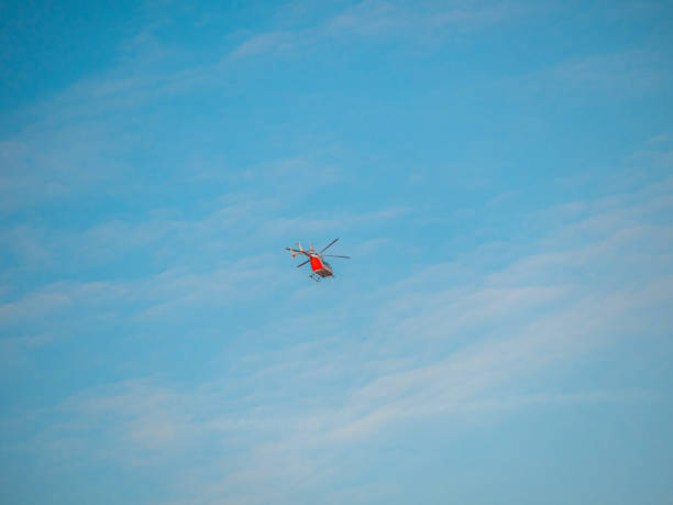 istock Far red helicopter in blue sky 1209035220