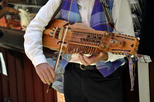 a young man plays an old swedish instrument called Nyckelharpa