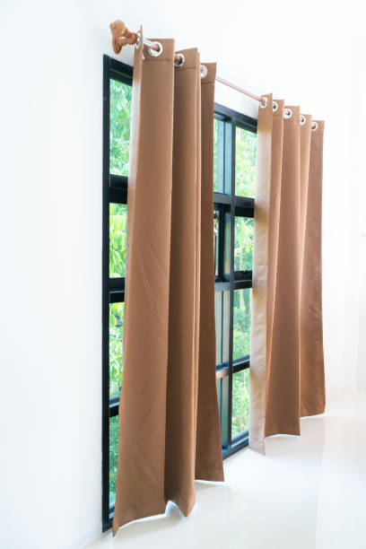 istock Beige curtain in cozy white bedroom 1209036092