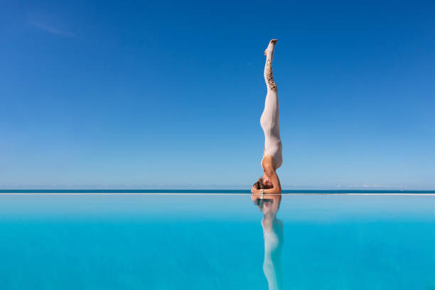 istock woman doing yoga on poolside. 1209036836