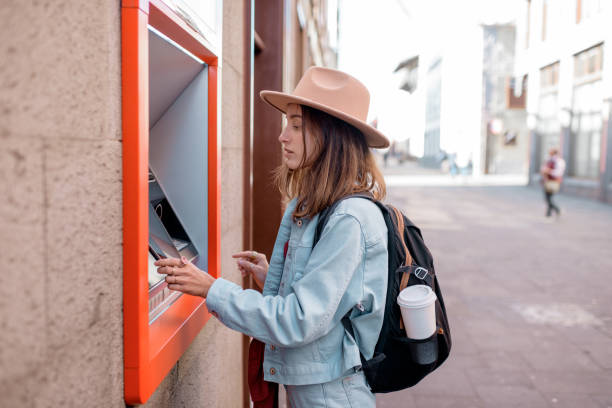 istock Woman using ATM on the street 1209039373
