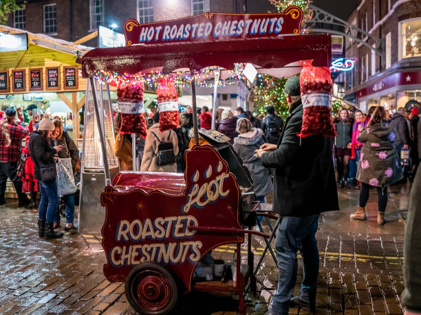ヨーク市のクリスマスマ��ーケットでホット栗を販売するモバイルカートを持つストリートベンダー - chestnut market vendor roasted christmas ストックフォトと画像