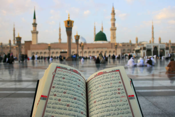 Reading Quran in front of Prophet Mosque Reading Quran in front of Prophet Mosque in Medina, Saudi Arabia al masjid an nabawi stock pictures, royalty-free photos & images
