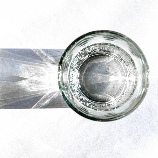 istock Water glass with strong shadows on white background 1209047630