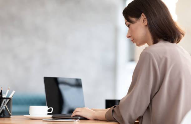 istock Focused young female worker working with laptop 1209049068