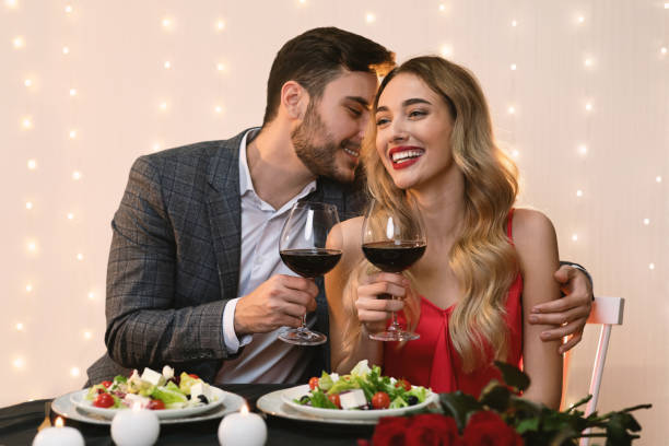 istock Affectionate man whispering love words to girlfriend on date in restaurant 1209049579