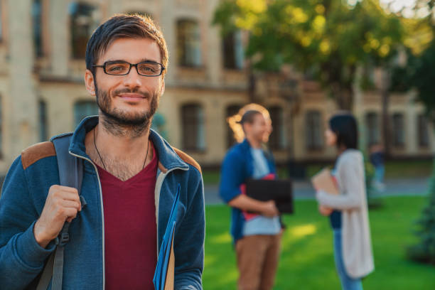 istock Mixed race male college student on modern campus with friends on background 1209049621