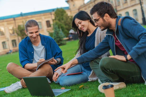 istock Group of university students working outside together 1209049717