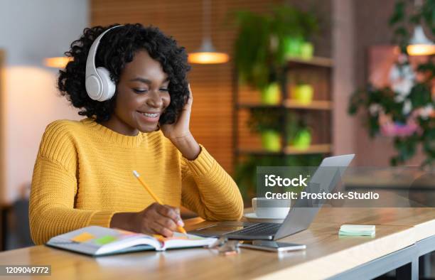 Black Girl In Headphones Studying Online Using Laptop At Cafe Stock Photo - Download Image Now