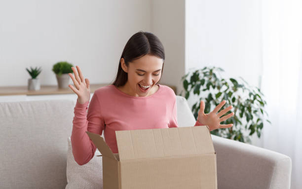 istock Overjoyed millennial woman opening cardboard box at home 1209049877
