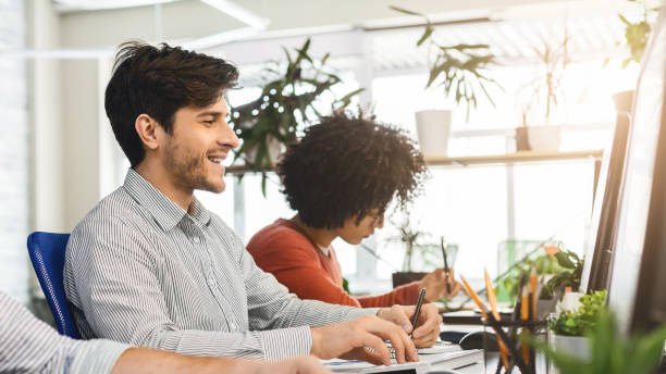 istock Young guy enjoying his job, working with colleagues in office 1209051819