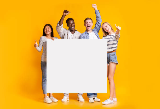 gruppo positivo di adolescenti in piedi insieme a cartelli bianchi - holding a sign foto e immagini stock