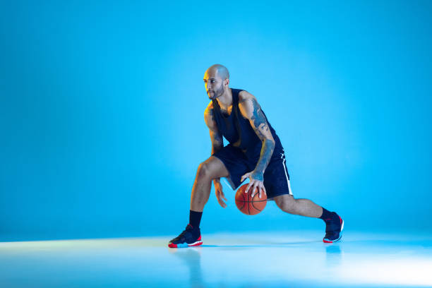 istock Young basketball player training isolated on blue studio background in neon light 1209055030