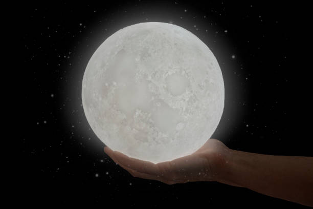 istock The moon hold by a human hand. 1209056790