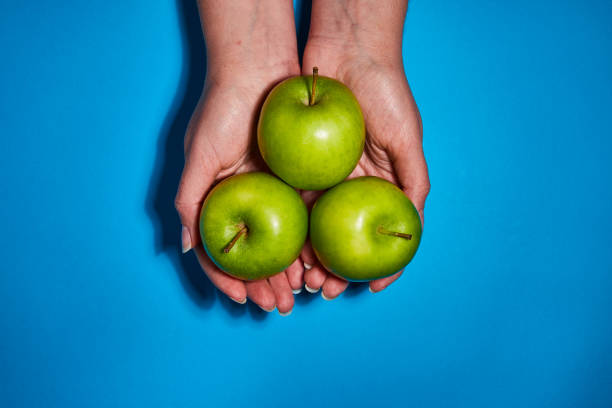 istock Lemon in hand on blue background. Flat lay, top view, copy space . Food dietary concept. 1209056912