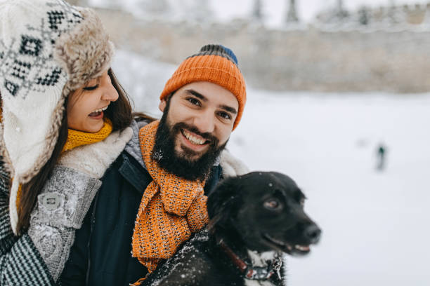 istock Couple in the snow play with dog 1209057176