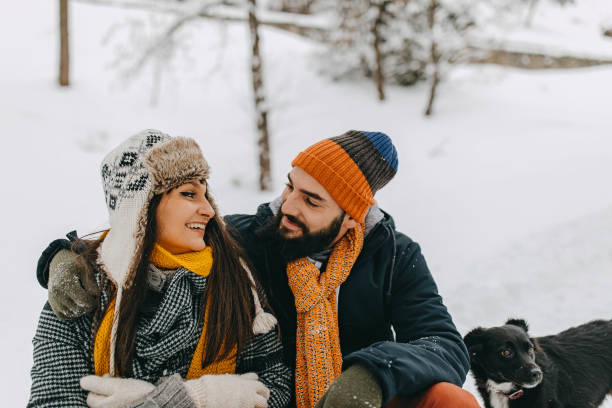 istock Couple in the snow play with dog 1209057178