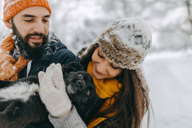 istock Couple in the snow play with dog 1209058040