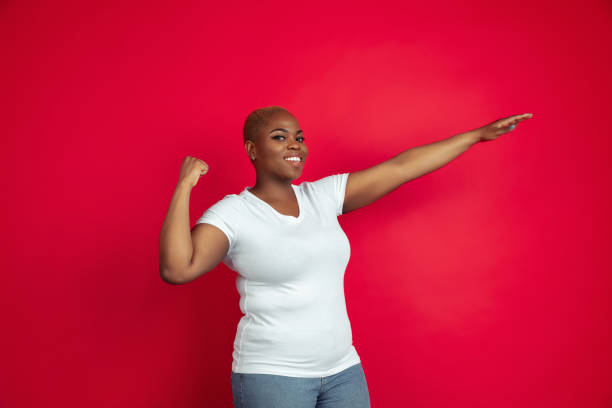 istock African-american young woman's portrait on red background 1209058182