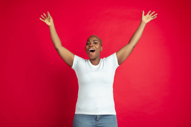 istock African-american young woman's portrait on red background 1209058235