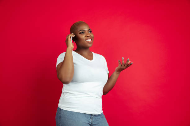 istock African-american young woman's portrait on red background 1209058284