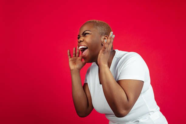 istock African-american young woman's portrait on red background 1209058317