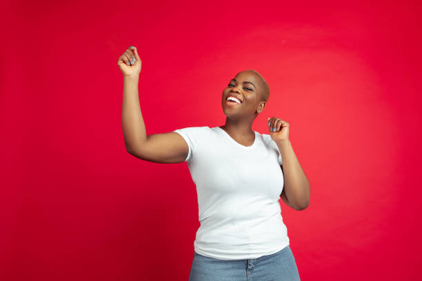 istock African-american young woman's portrait on red background 1209058385