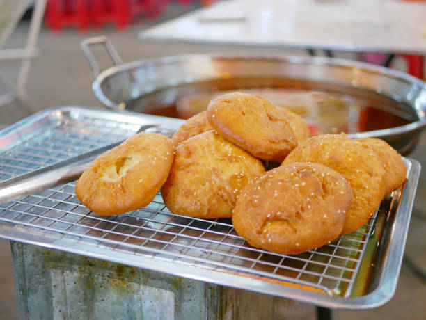 istock Fresh deep-fried dough (Pa Tong Go) with sesame seeds on a tray rack ready to be served 1209059941