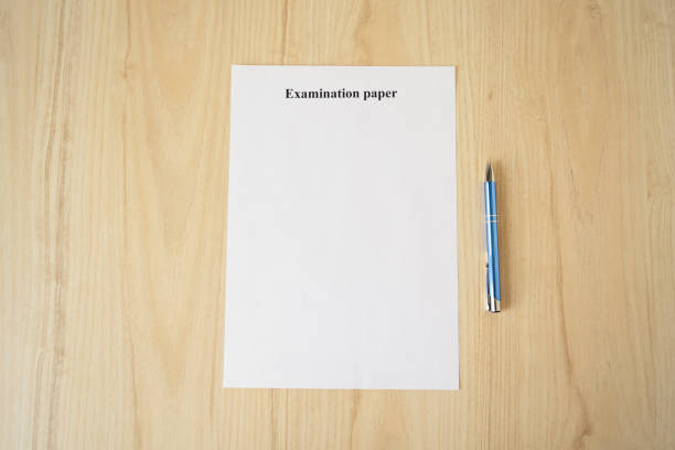 istock Empty examination paper for university with pen on the school desk. Copyspace. Mockup. Flat lay 1209062592