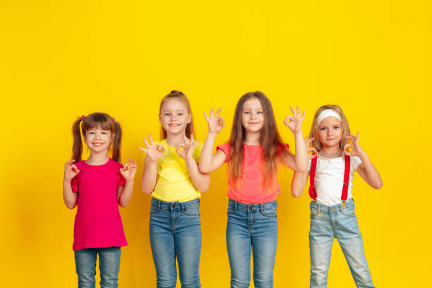 istock Happy children playing and having fun together on yellow studio background 1209064420