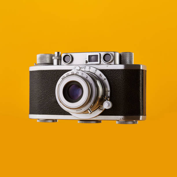 caméra de film de télémètre de cru d’isolement sur le fond jaune /orange coloré - rangefinder camera photos et images de collection