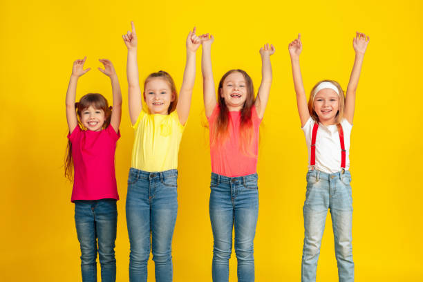 istock Happy children playing and having fun together on yellow studio background 1209064511